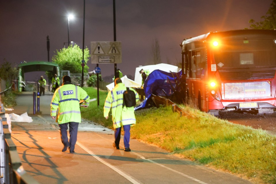 Police officers at the scene of a fatal bus and car collision.