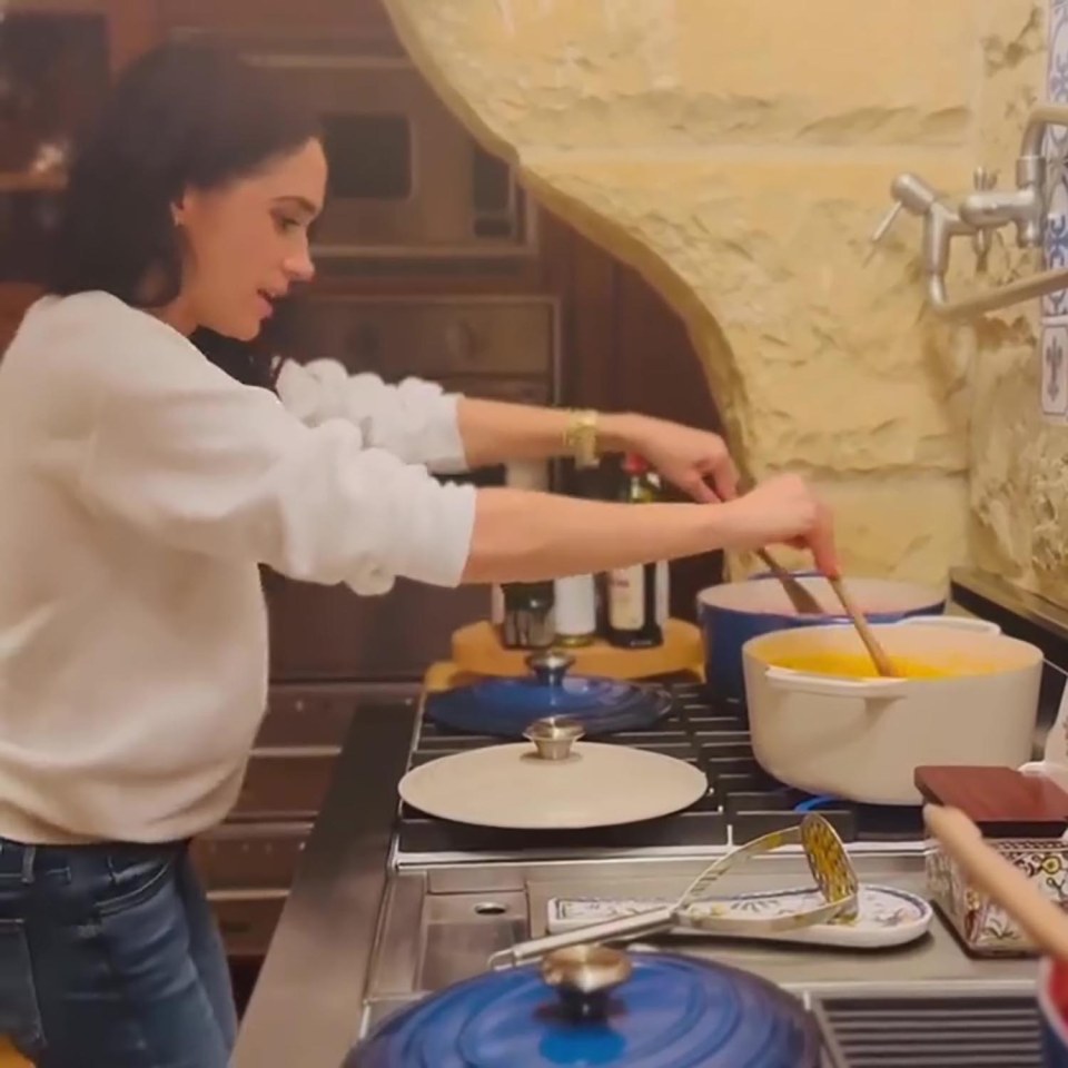 Meghan Markle cooking in a kitchen.