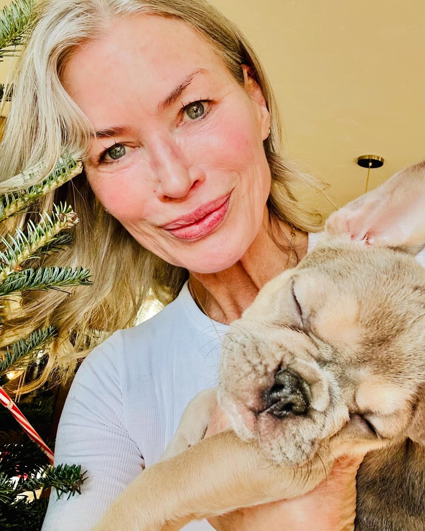 Carré Otis holding a French bulldog puppy.