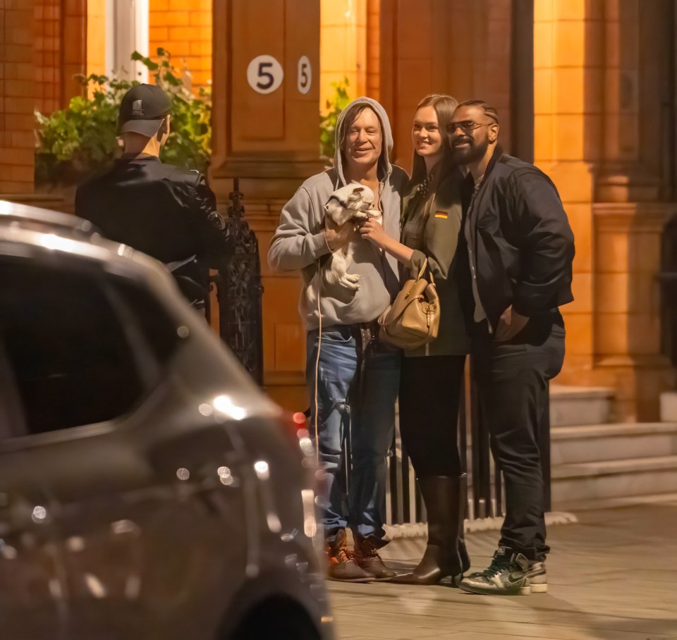 Mickey Rourke leaving a London hotel with a small dog and two companions.