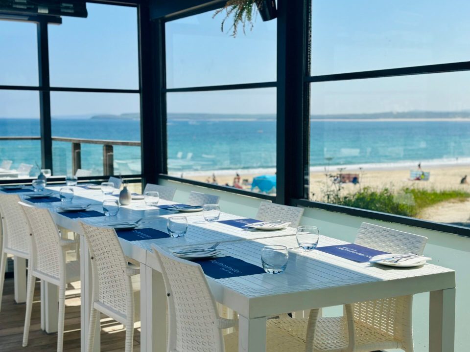 Ocean view restaurant tables set for diners.