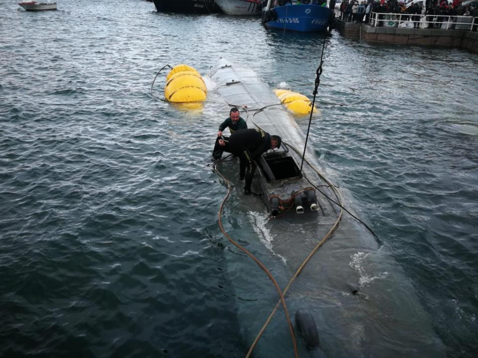 Customs officials inspecting a seized narco-submarine.