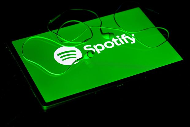 An image collage containing 1 images, Image 1 shows Photo illustration of the Spotify logo on a tablet with earbuds