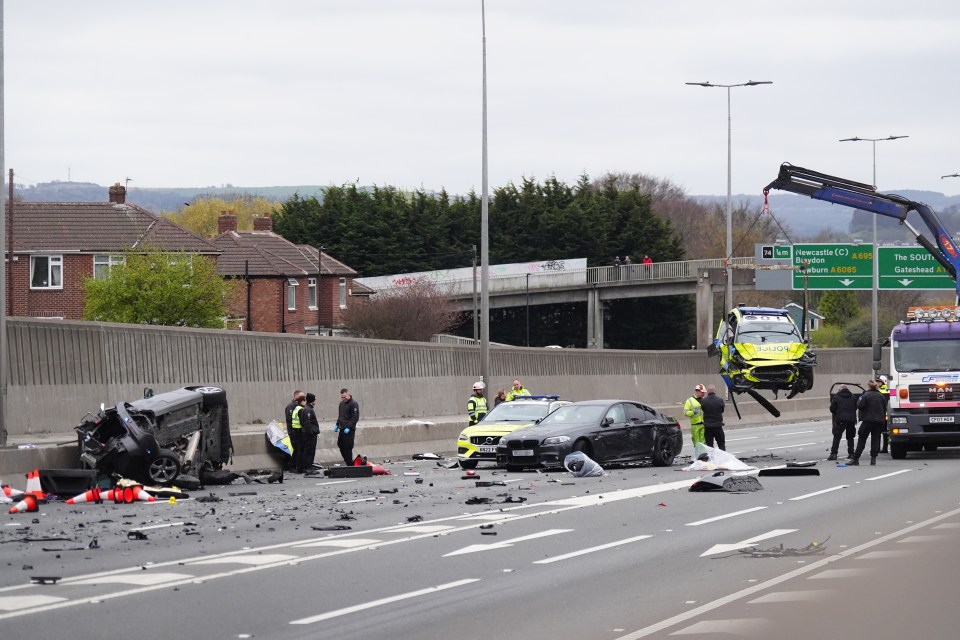 Damaged police car being lifted from A1 motorway after multi-vehicle collision.