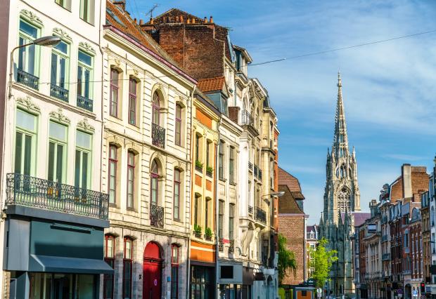 Traditional buildings in Lille, France, with a church spire in the background.