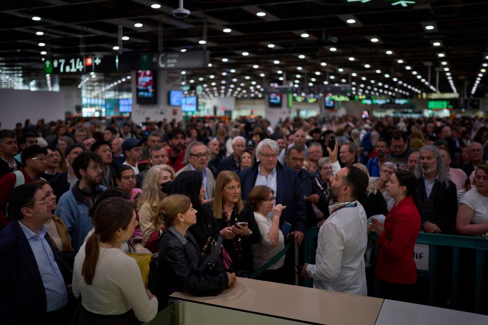 A large crowd of people waiting at a train station.