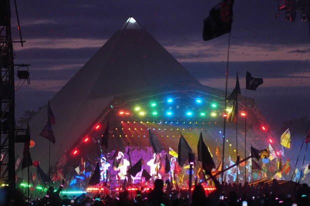Coldplay performing at Glastonbury Festival on the Pyramid Stage.