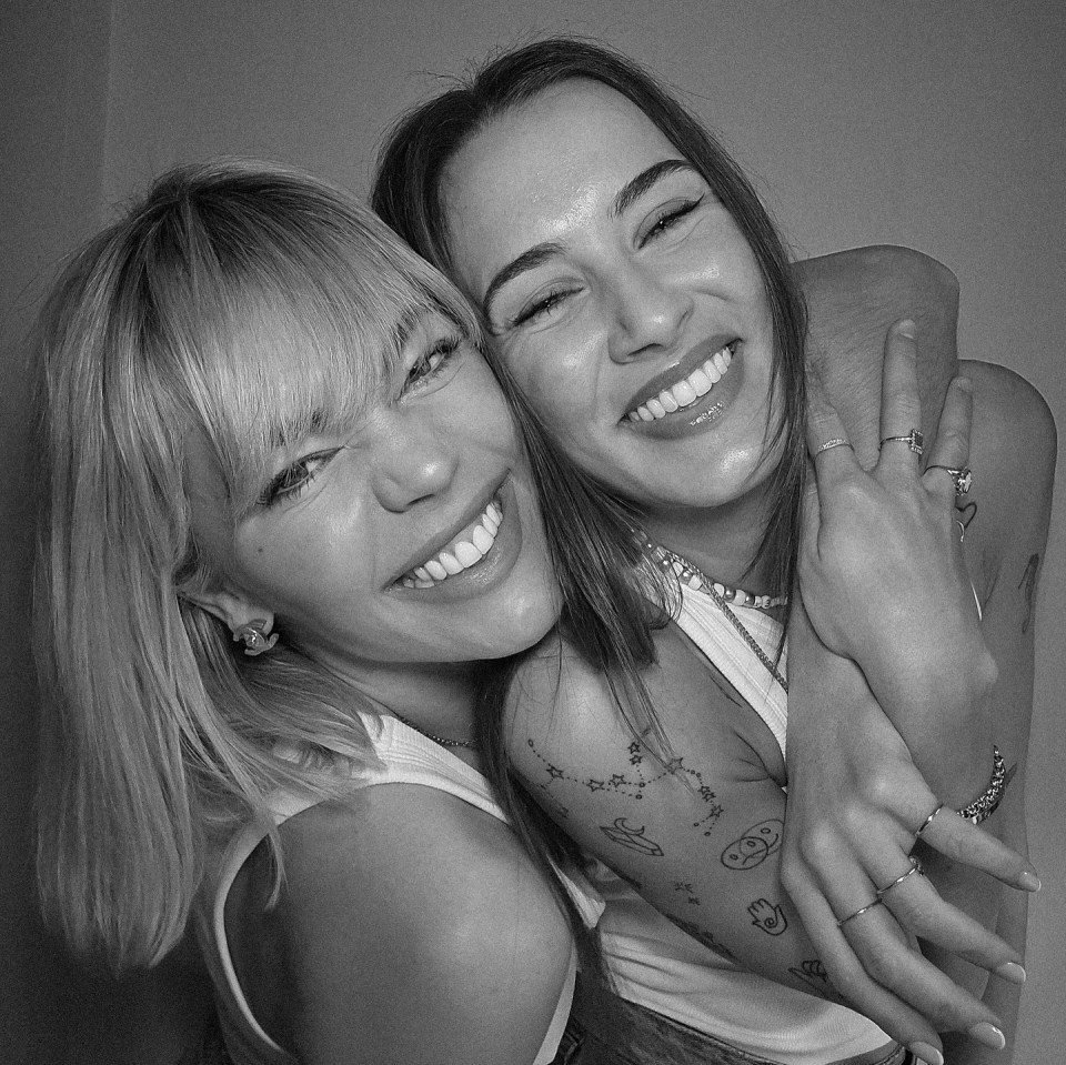 Black and white photo of two smiling women embracing.