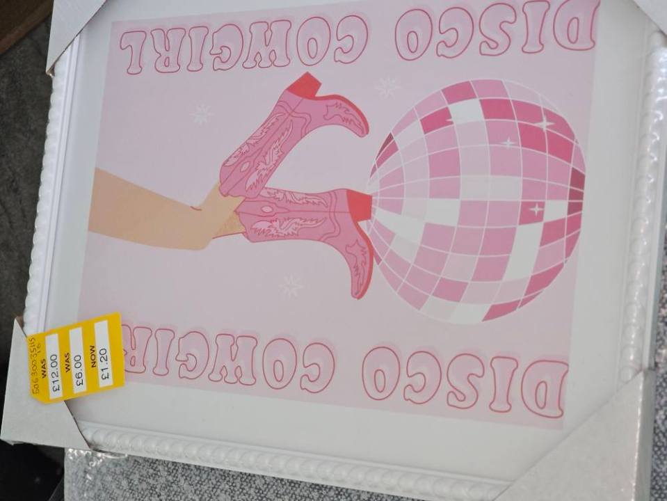 Illustration of a framed print showing pink cowboy boots and a disco ball with the text "Disco Cowgirl".