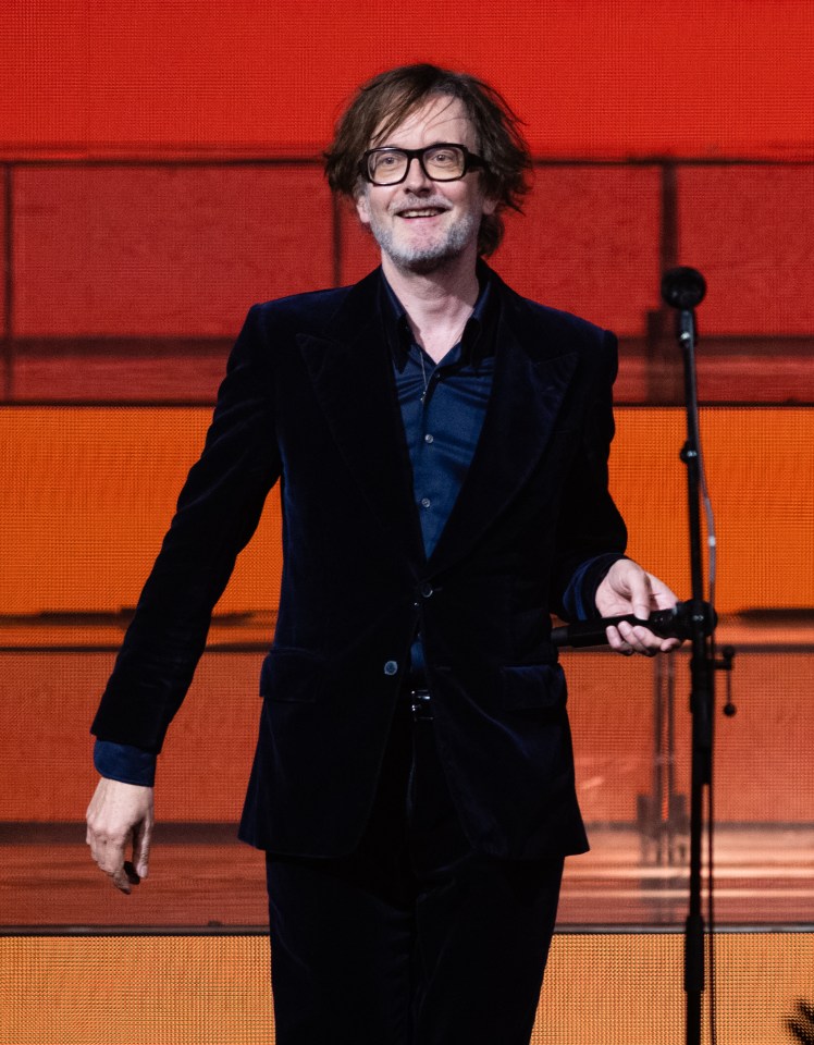 Jarvis Cocker of Pulp performing on stage.