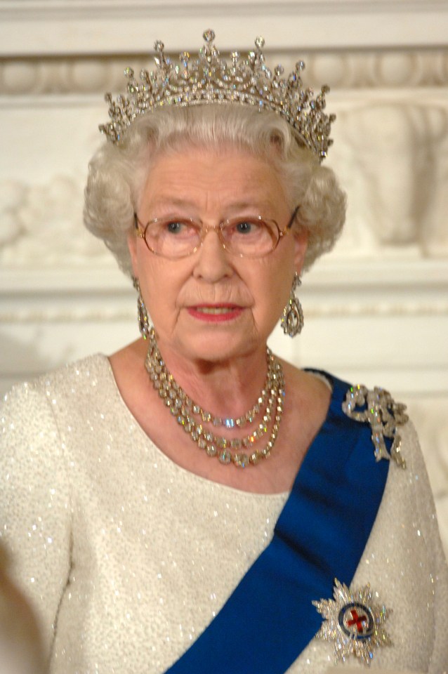 Queen Elizabeth II wearing a tiara, necklace, earrings, and sash.