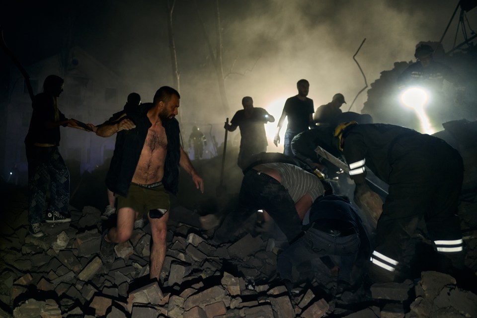 Rescuers and civilians searching for victims in the rubble of a destroyed building.