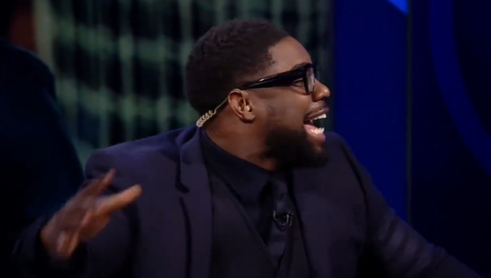 Man in suit and glasses laughing.