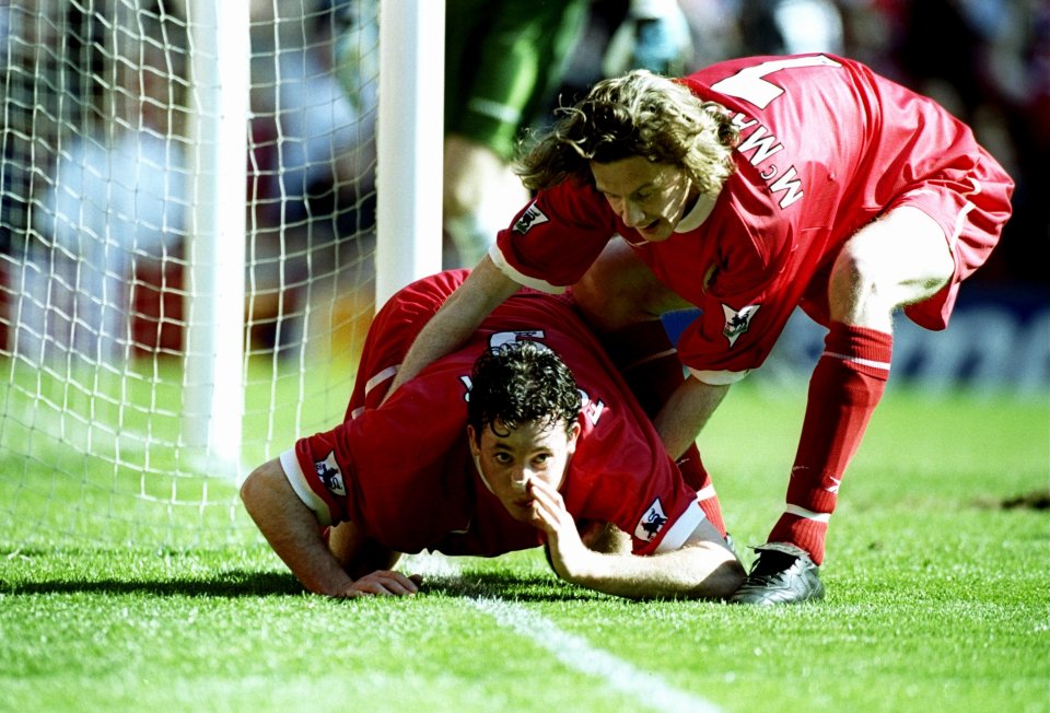 Robbie Fowler of Liverpool being pulled away by a teammate after celebrating a goal.