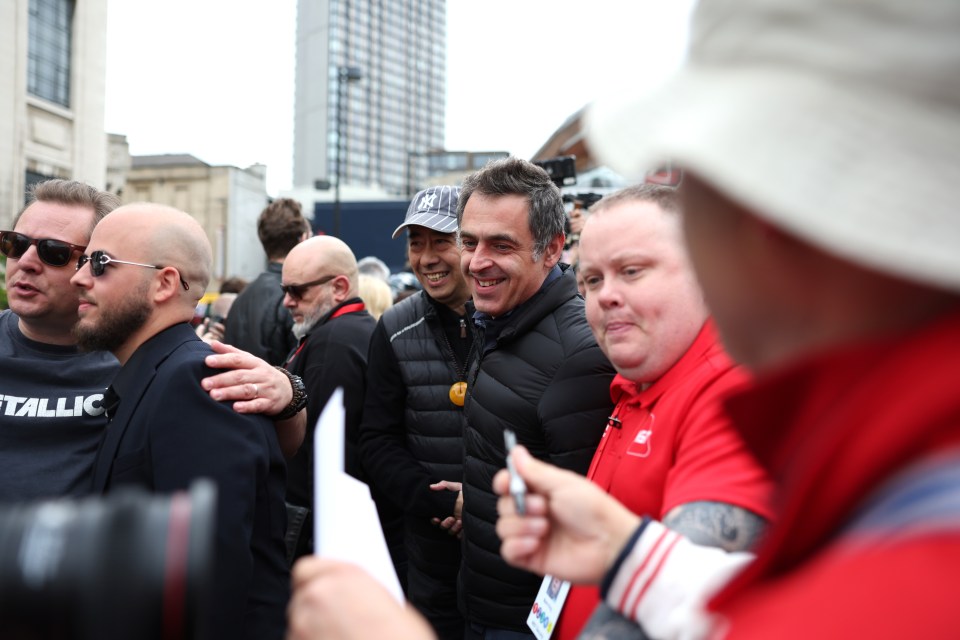 Ronnie O'Sullivan arriving at the Crucible Theatre, surrounded by people.
