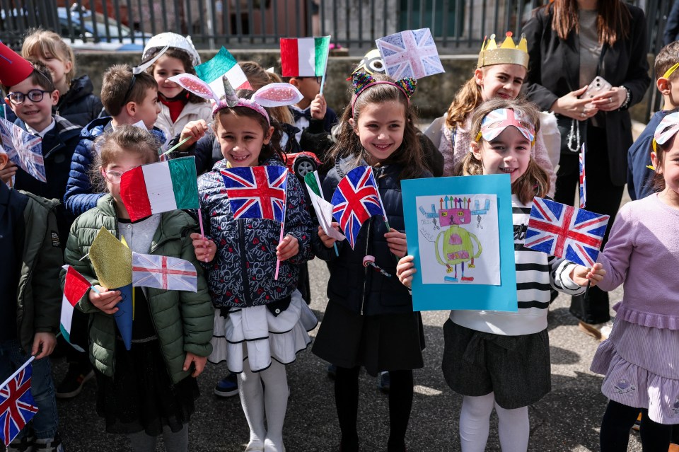Schoolchildren holding British and Italian flags.