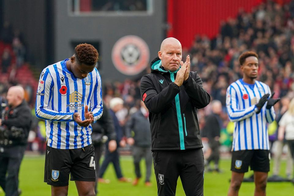Sheffield Wednesday assistant manager and players applauding fans.