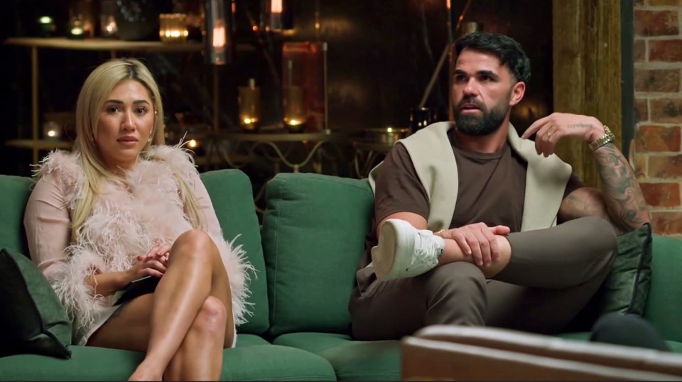 A Married at First Sight Australia couple sits on a couch.