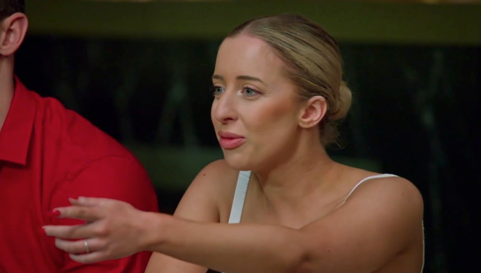 A woman from Married at First Sight Australia gestures during a tense group meeting.
