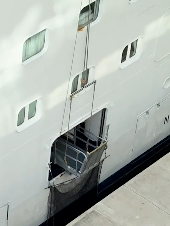 A cruise ship's gangway lowered to the dock.