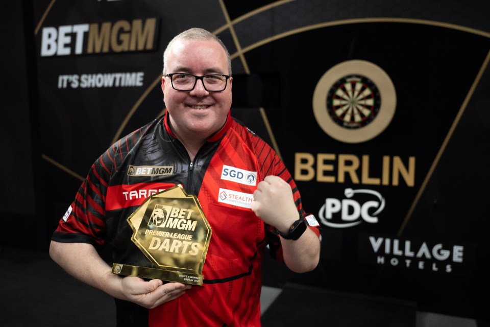 Stephen Bunting holding a Premier League Darts trophy.