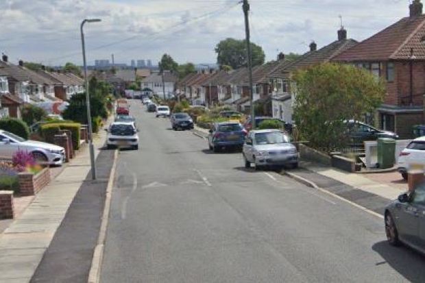 Residential street with parked cars.