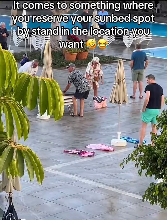 Tourists reserving sunbeds by placing towels on them.
