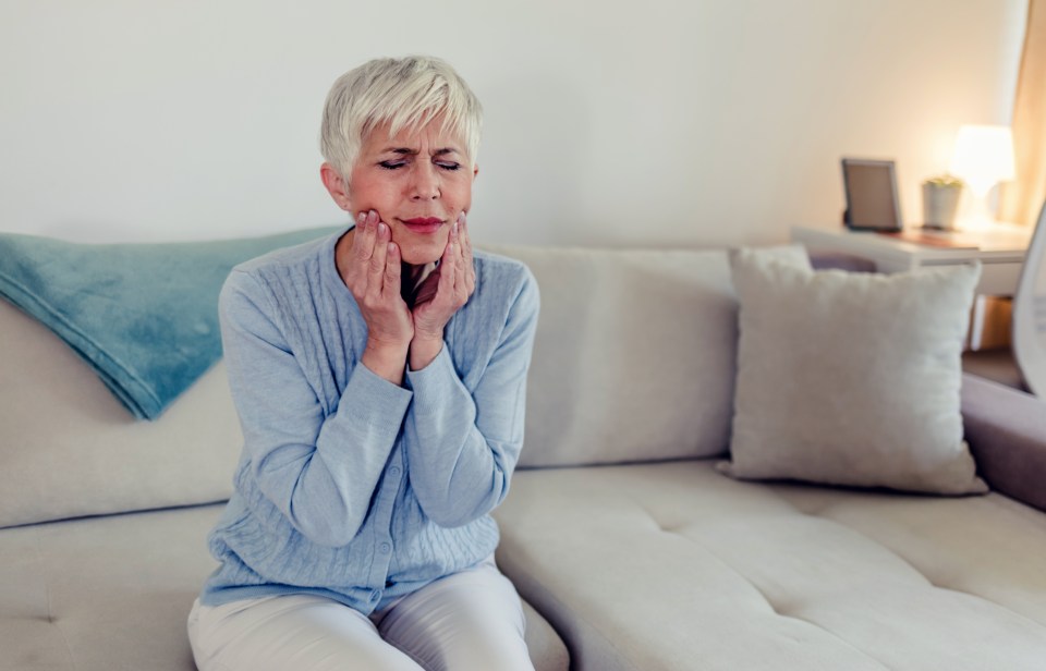 Woman experiencing tooth pain.