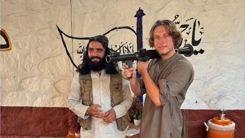 Two men posing with a rocket launcher.