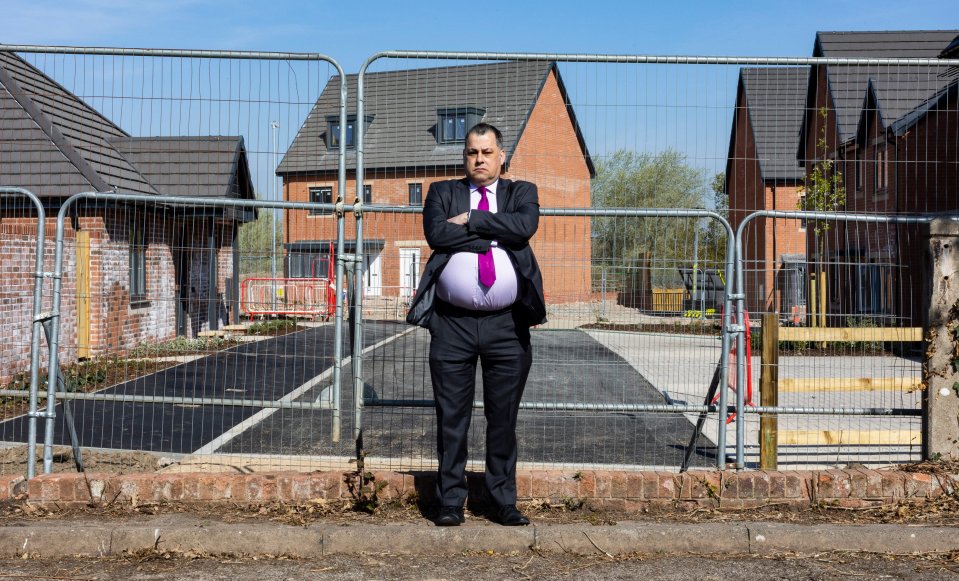 A man stands arms crossed in front of a construction site.