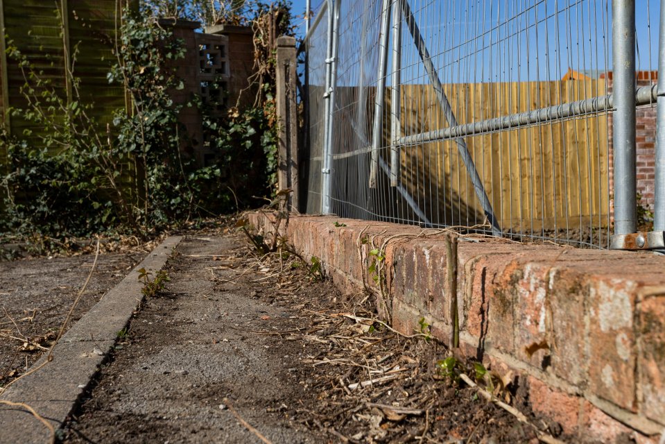 Low brick wall next to a construction site.