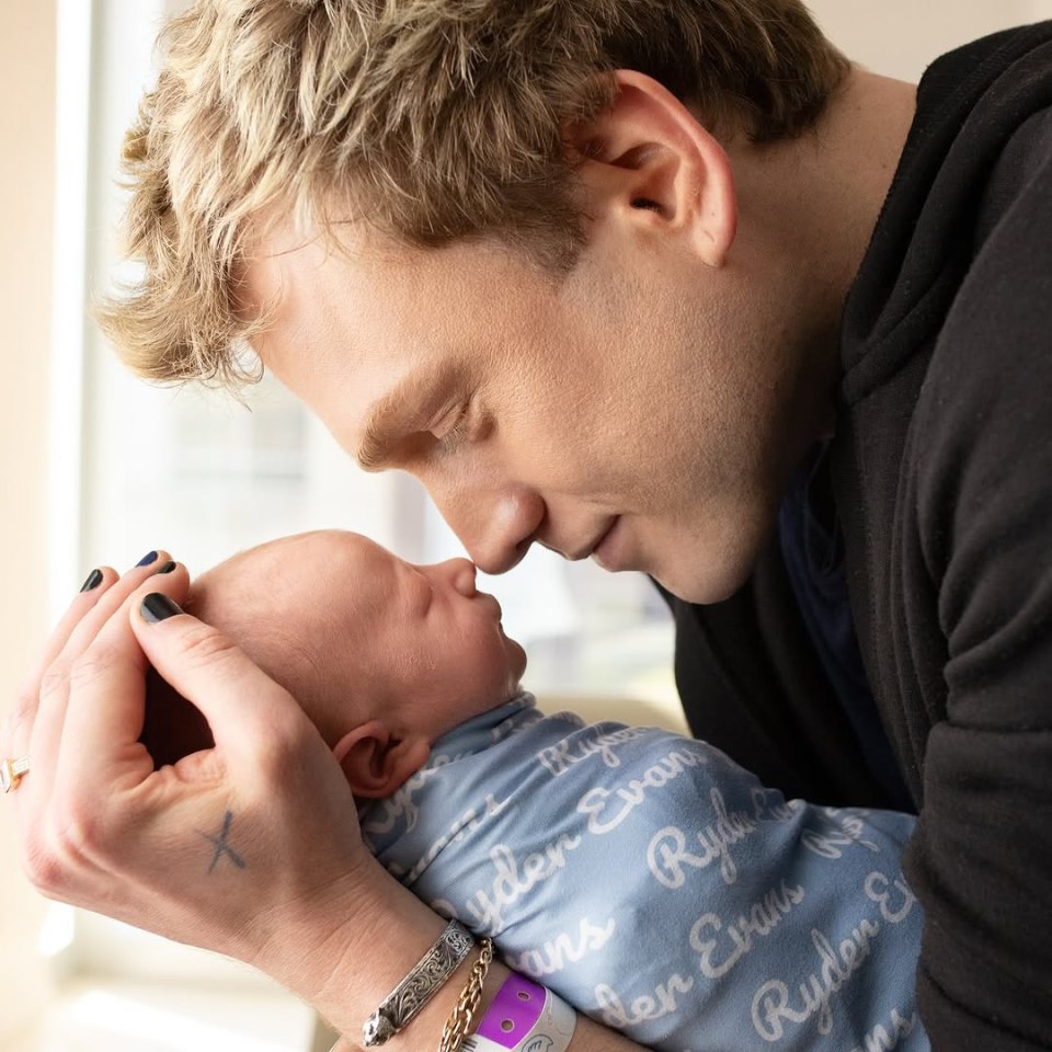 A father cradles his newborn son.