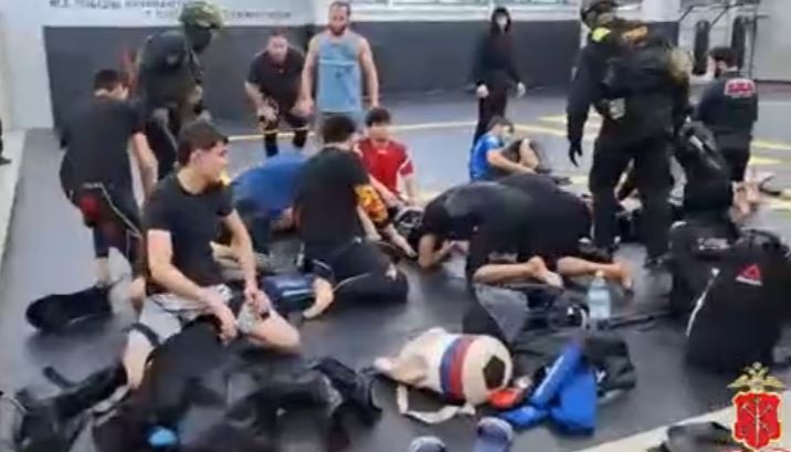 Russian police detaining men at a gym.