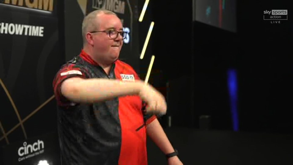 A darts player throwing a dart.