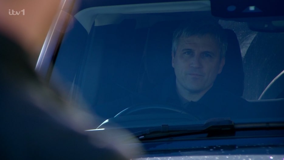 Caleb from Emmerdale in a car, looking serious.