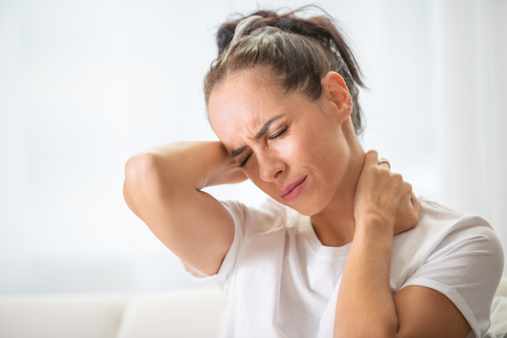Woman holding her neck in pain.