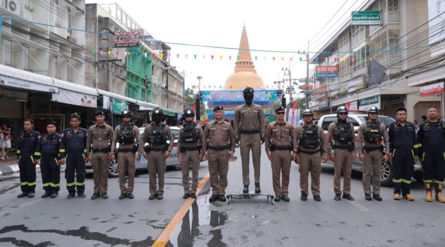 Group of police officers and emergency personnel standing in formation on a city street.