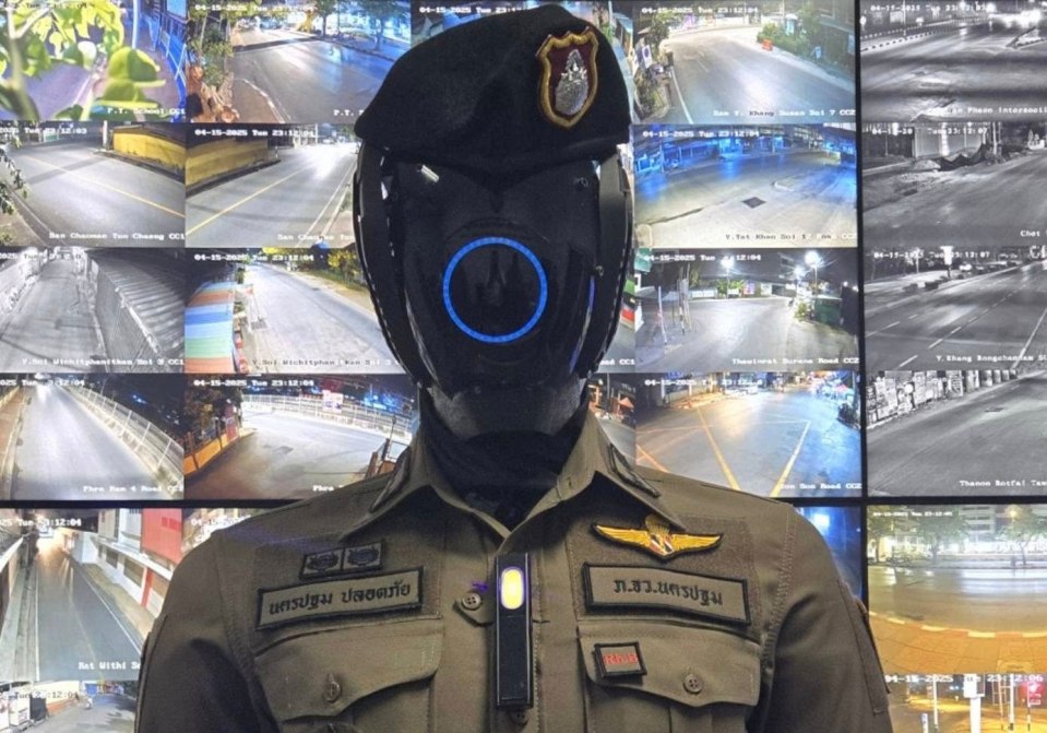 Robot police officer in front of security camera monitors.