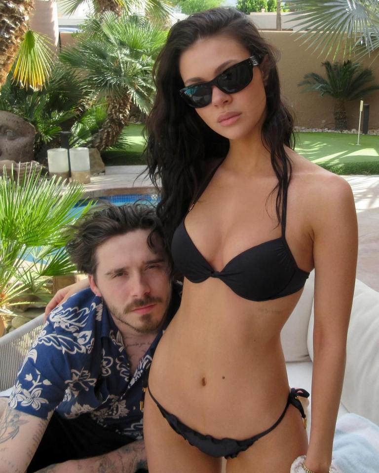 Woman in a black bikini with a man in a floral shirt.