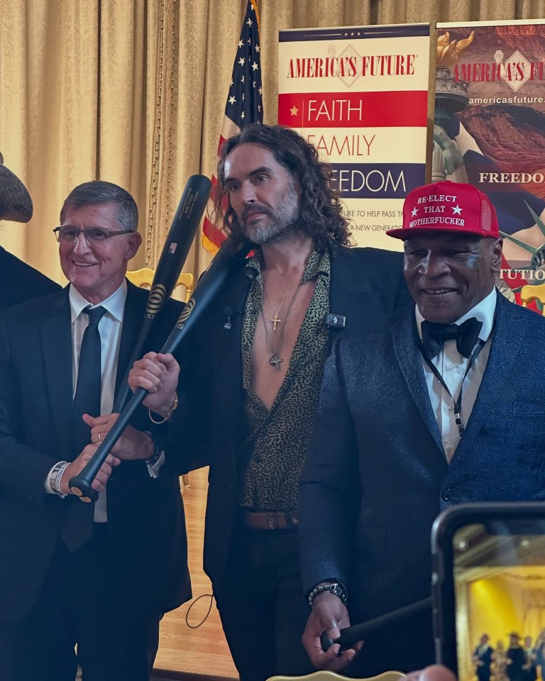 Russell Brand, Mike Tyson, and another man posing together.