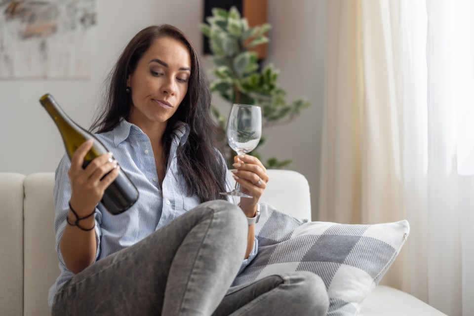 Woman considering drinking wine.
