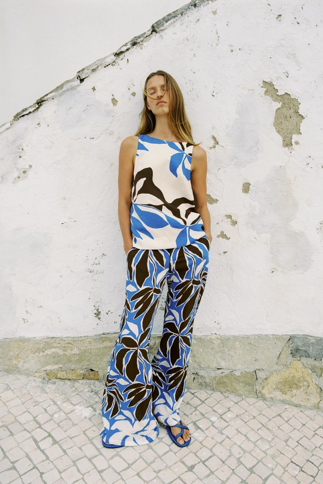 Woman in blue and brown floral print pants and top.