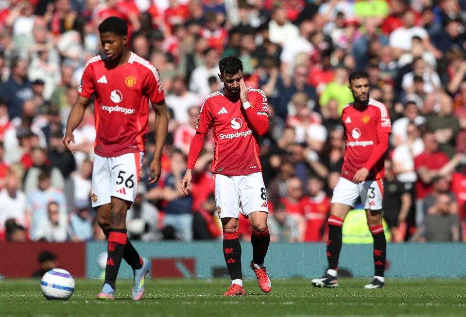 Manchester United players looking dejected on the pitch.