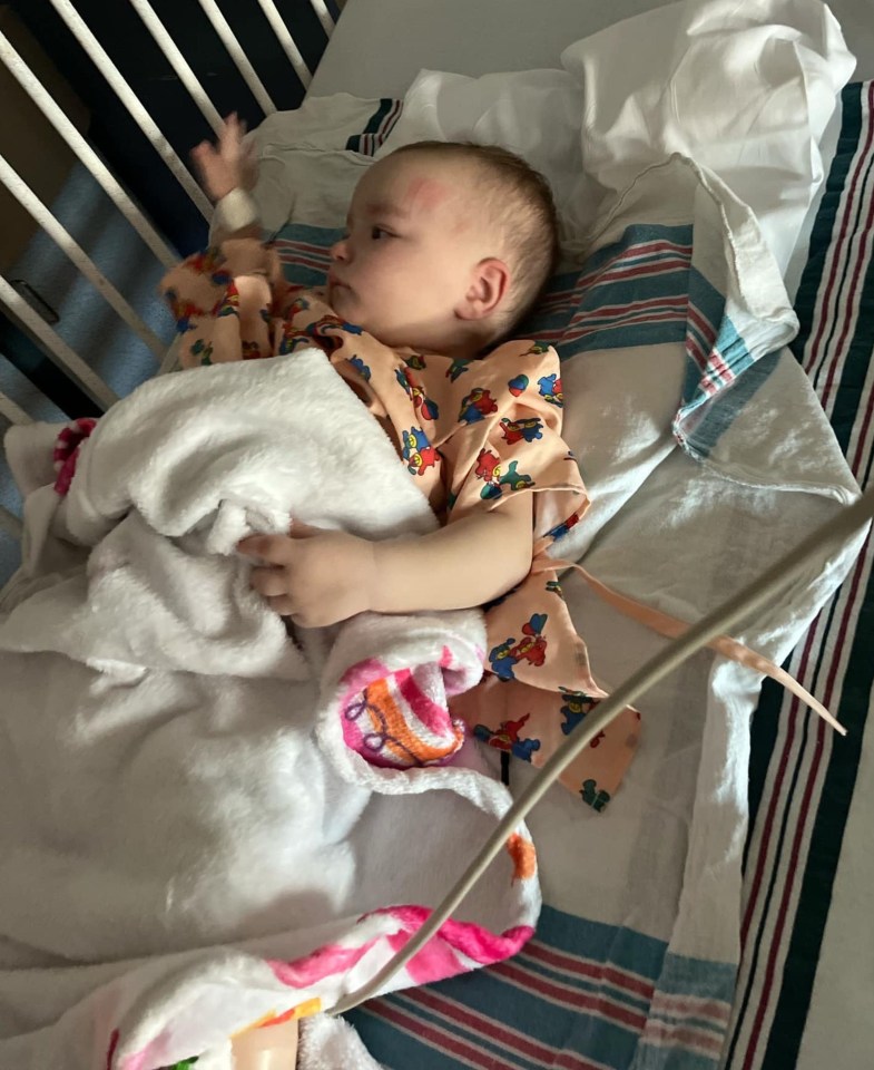 A baby girl lying in a hospital crib.