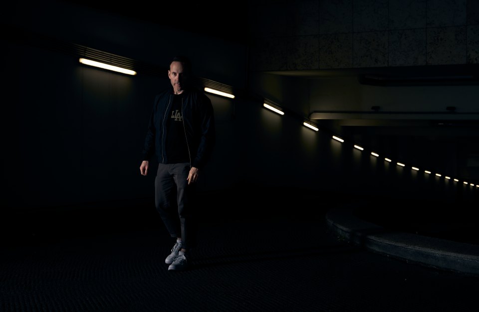 Dan Curtin, techno pioneer, standing in a dimly lit underpass.