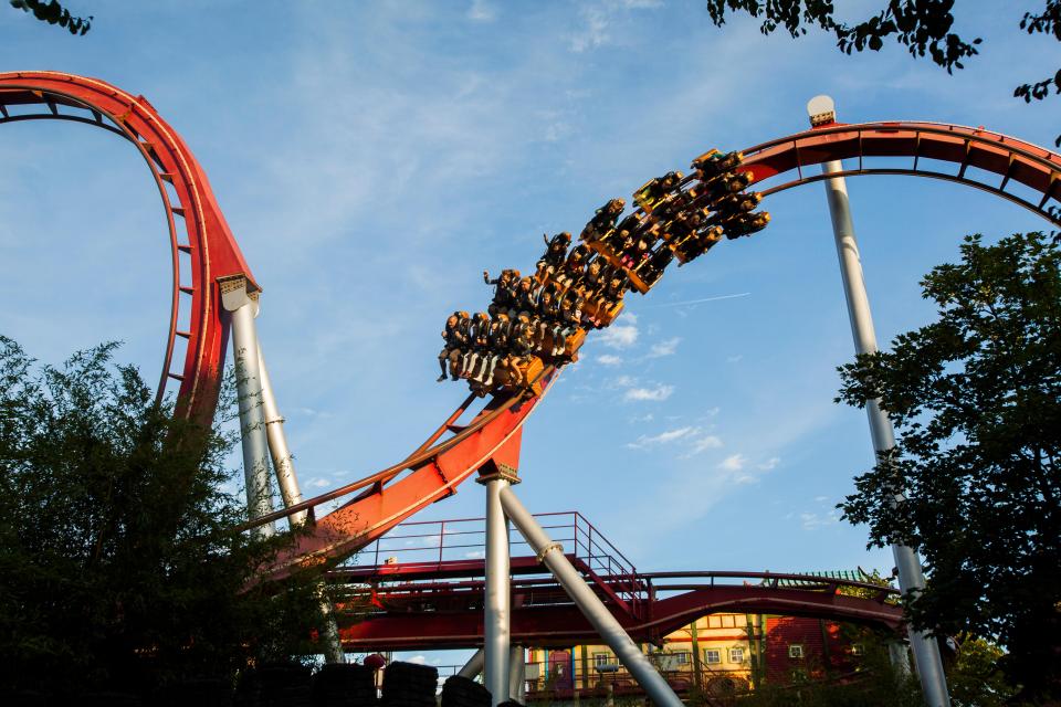 Rollercoaster riders soaring through a loop.