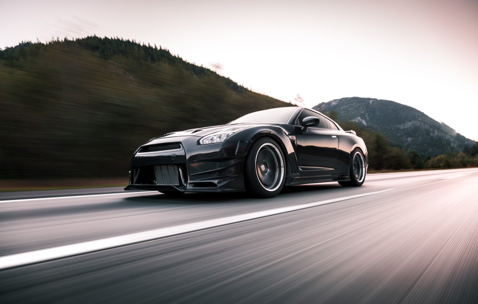 Black Nissan GT-R driving on a highway.