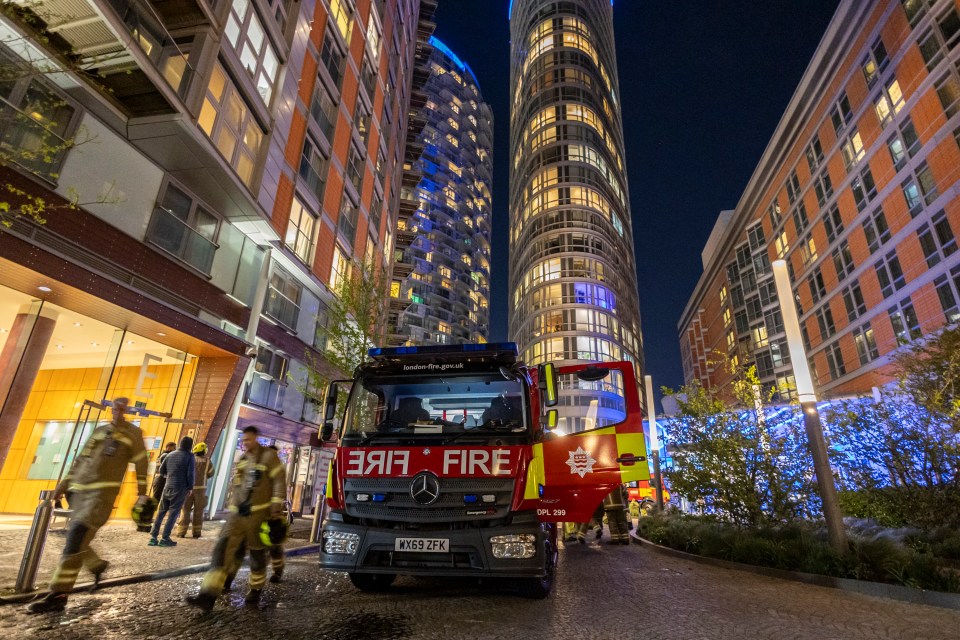 Firefighters and a fire engine at the scene of a fire in a London apartment building.