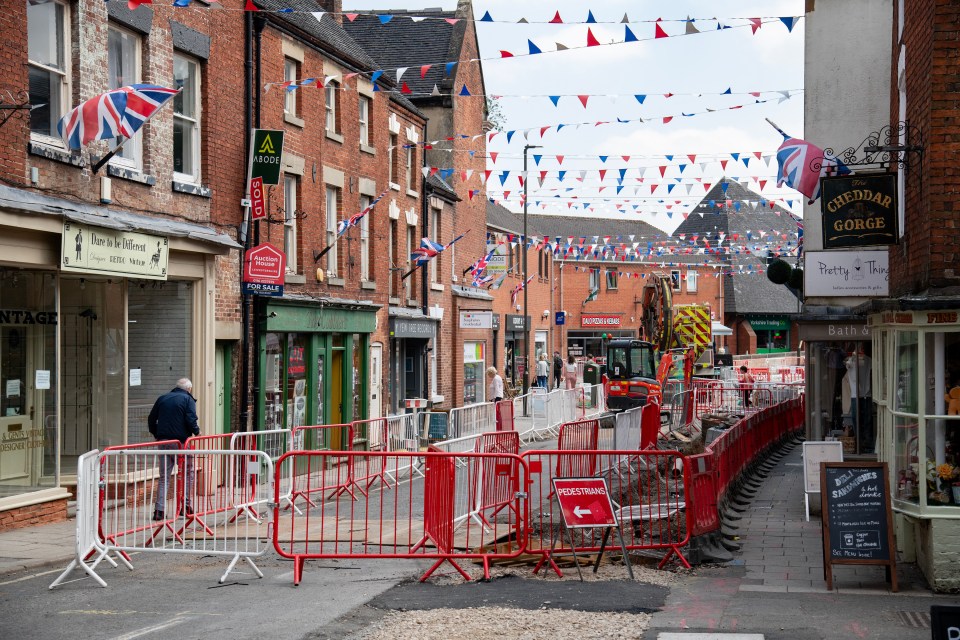 Roadworks blocking a street in a small town.