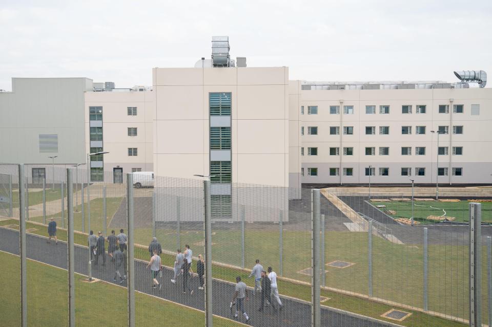 General view of HMP Five Wells, a Category C prison in Wellingborough, with prisoners walking in an exercise yard.